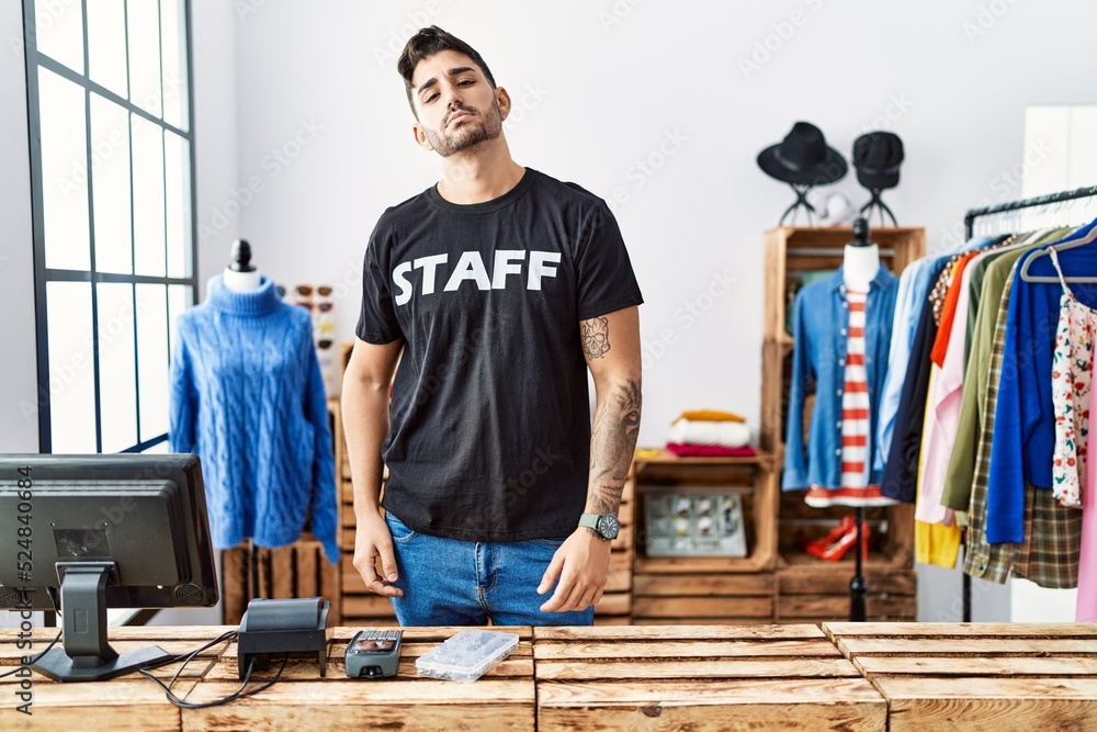 Young hispanic man working at retail boutique looking sleepy and tired, exhausted for fatigue and hangover, lazy eyes in the morning. Young hispanic man working at retail boutique looking sleepy and tired, exhausted for fatigue and hangover, lazy eyes in the morning.