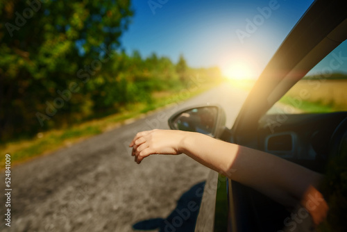 Woman's hand outside car window. Summer vacations concept.