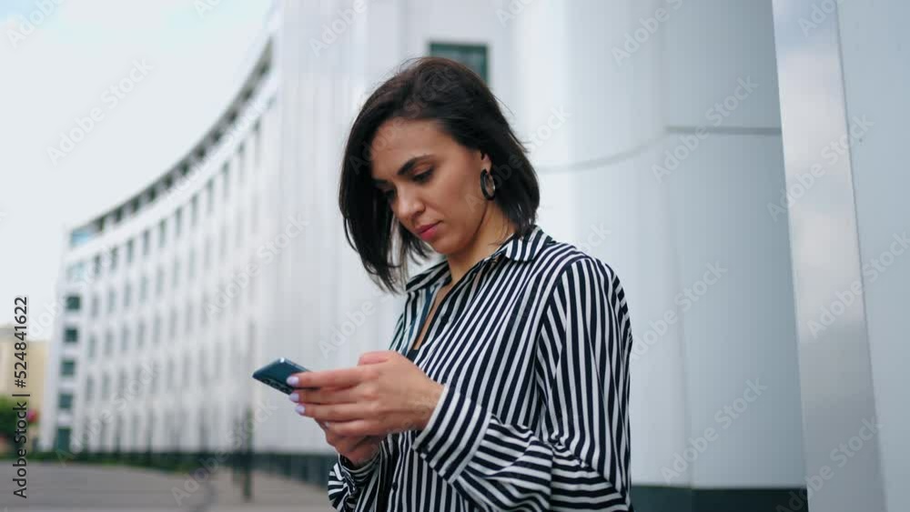 businesswoman is checking email and financial news in smartphone, portrait of young lady outdoors businesswoman is checking email and financial news in smartphone, portrait of young lady outdoors