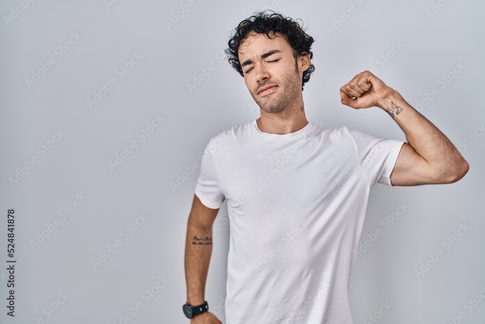 Hispanic man standing over isolated background stretching back, tired and relaxed, sleepy and yawning for early morning Hispanic man standing over isolated background stretching back, tired and relaxed, sleepy and yawning for early morning