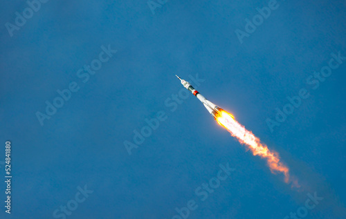 Fototapeta Naklejka Na Ścianę i Meble -  Take-off of a real launch vehicle from a spaceport. A rocket takes off into the sky against a background of clouds. Startup concept, power of science and technology.