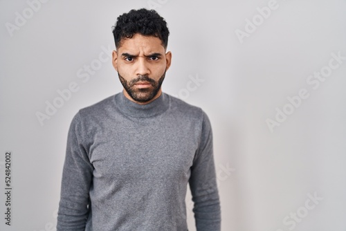 Hispanic man with beard standing over white background skeptic and nervous, frowning upset because of problem. negative person. © Krakenimages.com
