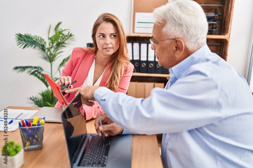 Obraz premium Middle age man and woman business workers working at office