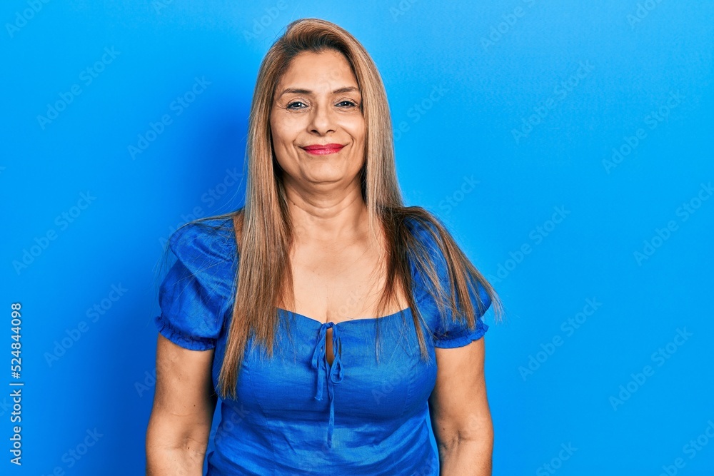 Middle age hispanic woman wearing casual clothes with serious expression on face. simple and natural looking at the camera. Middle age hispanic woman wearing casual clothes with serious expression on face. simple and natural looking at the camera.