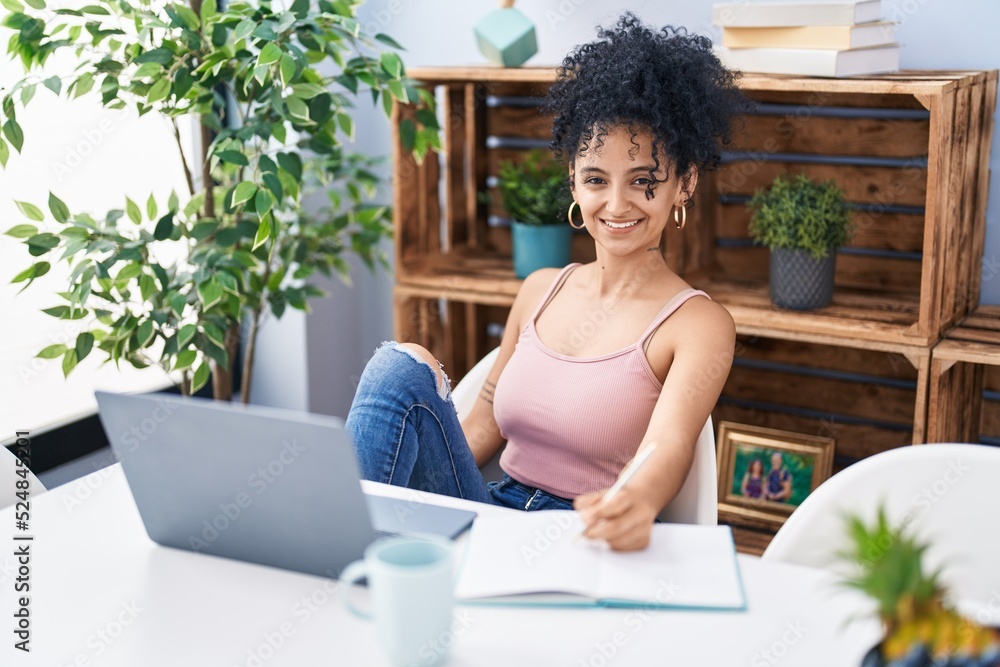 Young hispanic woman studying and drinking coffee at home Young hispanic woman studying and drinking coffee at home
