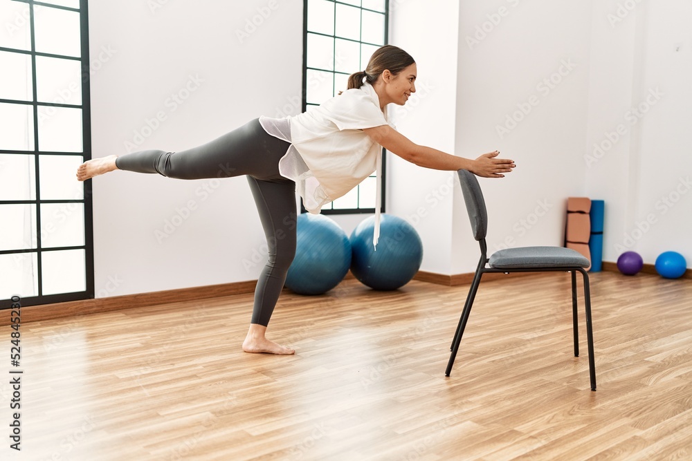 Young hispanic woman smiling confident stretching at sport center. Young hispanic woman smiling confident stretching at sport center.