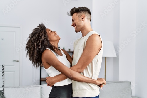 Obraz na plátně Man and woman couple smiling confident hugging each other at home