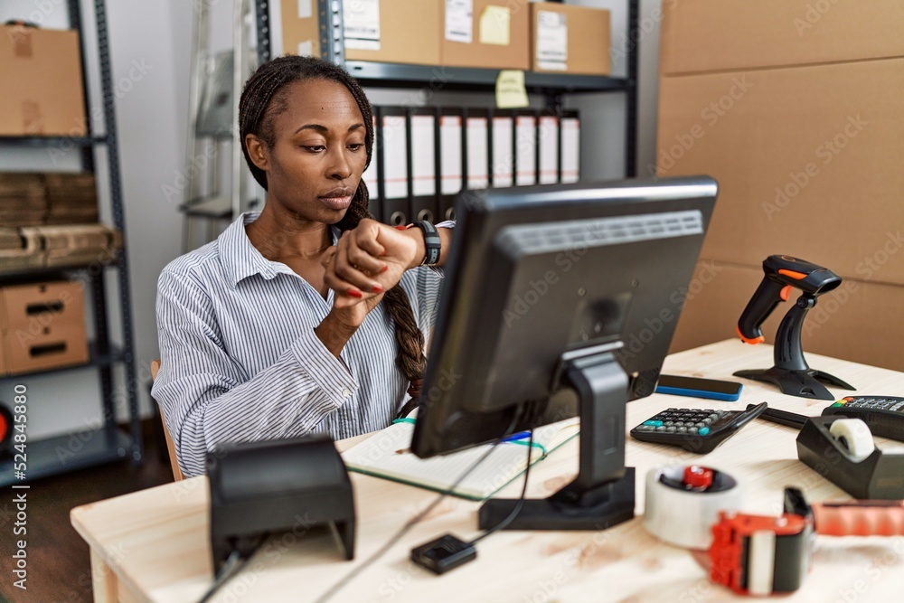 African woman working at small business ecommerce checking the time on wrist watch, relaxed and confident African woman working at small business ecommerce checking the time on wrist watch, relaxed and confident