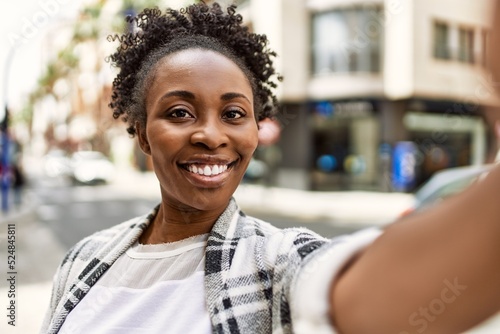 Young african american girl smiling happy make selfie by the smartphone at the city.