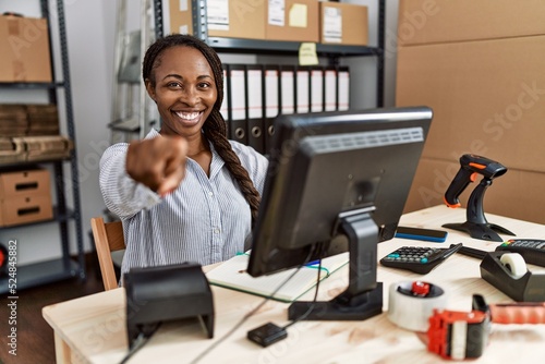 African woman working at small business ecommerce pointing to you and the camera with fingers, smiling positive and cheerful