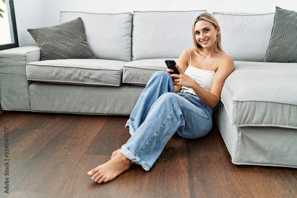 Young blonde woman smiling confident using smartphone at home