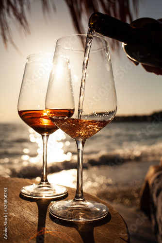 Two glasses of rose wine against the sunset sky.