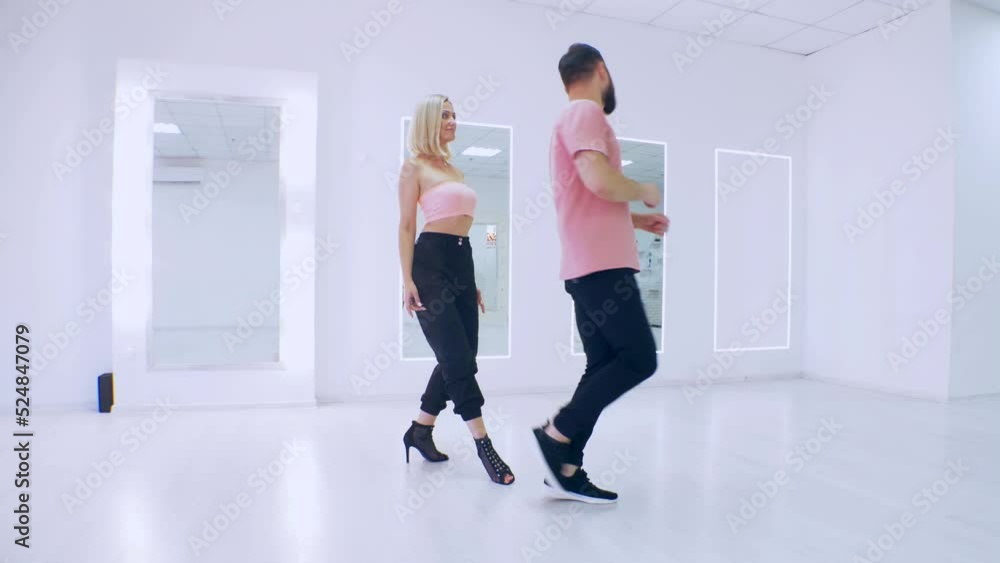 Man and woman dancing kizomba in white studio. A boy and a girl dance beautifully. Man and woman dancing kizomba in white studio. A boy and a girl dance beautifully.