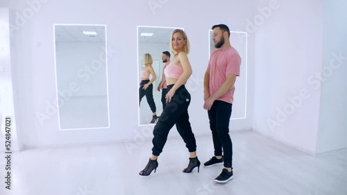 Man and woman dancing kizomba in white studio. A boy and a girl dance beautifully. photo