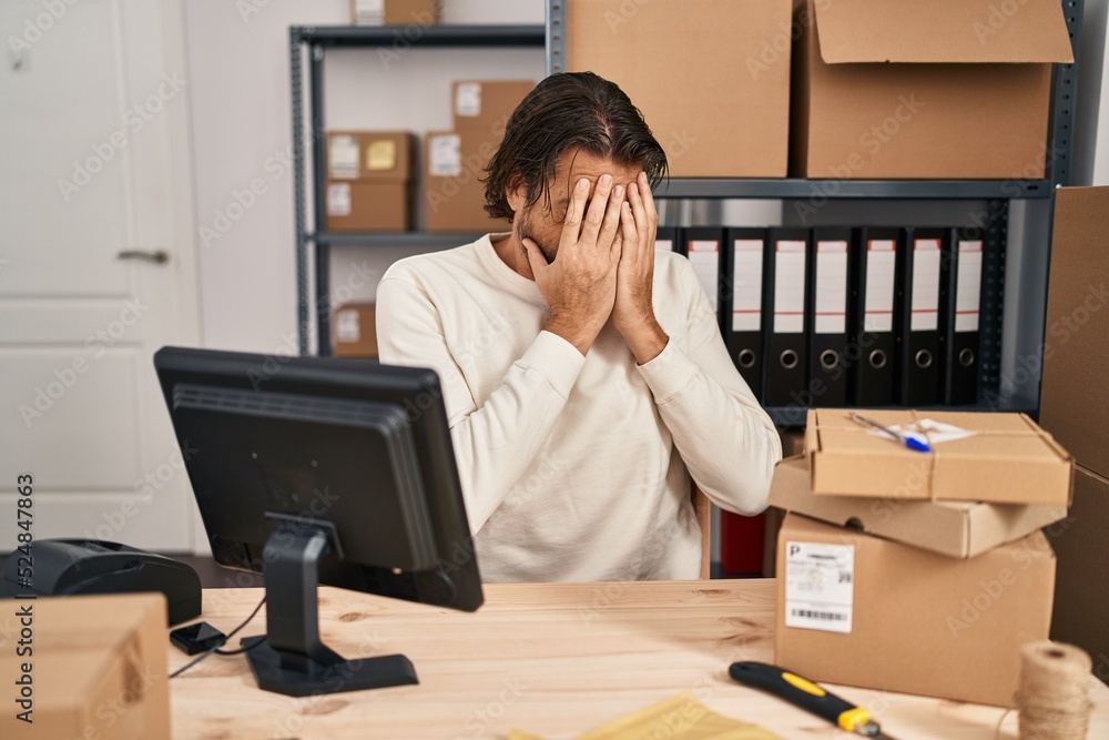 Handsome middle age man working at small business ecommerce with sad expression covering face with hands while crying. depression concept. Handsome middle age man working at small business ecommerce with sad expression covering face with hands while crying. depression concept.