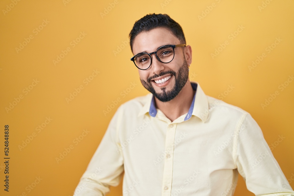 Hispanic young man wearing business clothes and glasses smiling cheerful with open arms as friendly welcome, positive and confident greetings Hispanic young man wearing business clothes and glasses smiling cheerful with open arms as friendly welcome, positive and confident greetings