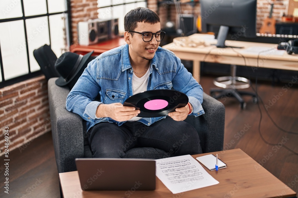 Young man musician hoding vinyl disc at music studio Young man musician hoding vinyl disc at music studio