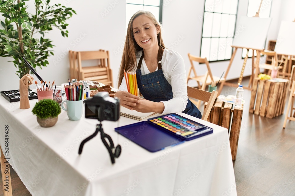 Young caucasian woman smiling confident recording drawing tutorial at art studio