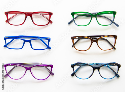 multicolored glasses for vision are lying on a white table
