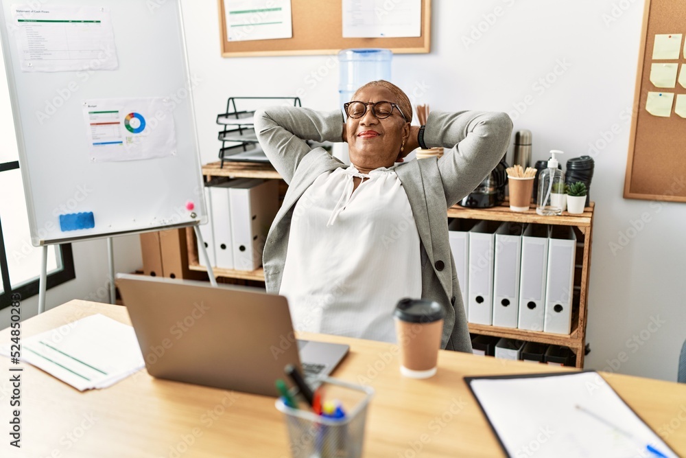 Senior african american woman business worker relaxed with hands on head at office Senior african american woman business worker relaxed with hands on head at office