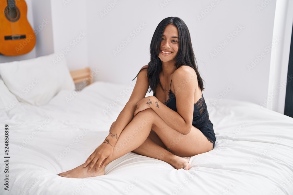 Young hispanic woman smiling confident sitting on bed at bedroom Young hispanic woman smiling confident sitting on bed at bedroom