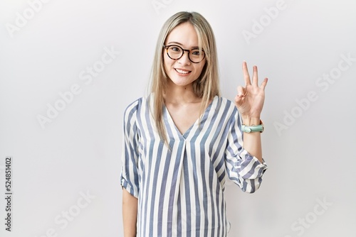 Wallpaper Mural Asian young woman wearing casual clothes and glasses showing and pointing up with fingers number three while smiling confident and happy. Torontodigital.ca