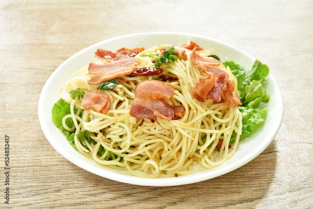 fried spaghetti topping crispy bacon and slice dry chili on plate fried spaghetti topping crispy bacon and slice dry chili on plate