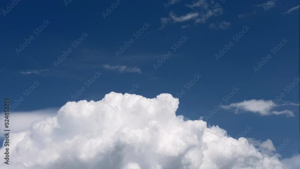 White cumulonimbus clouds swelling and rising up in the blue sky. Timelapse footage. Cloudscape, Japan