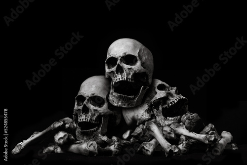 Awesome pile of skull human and bone on wooden, black cloth background, concept of scary crime scene of horror or thriller movies,Halloween theme, Still Life style, selective focus,