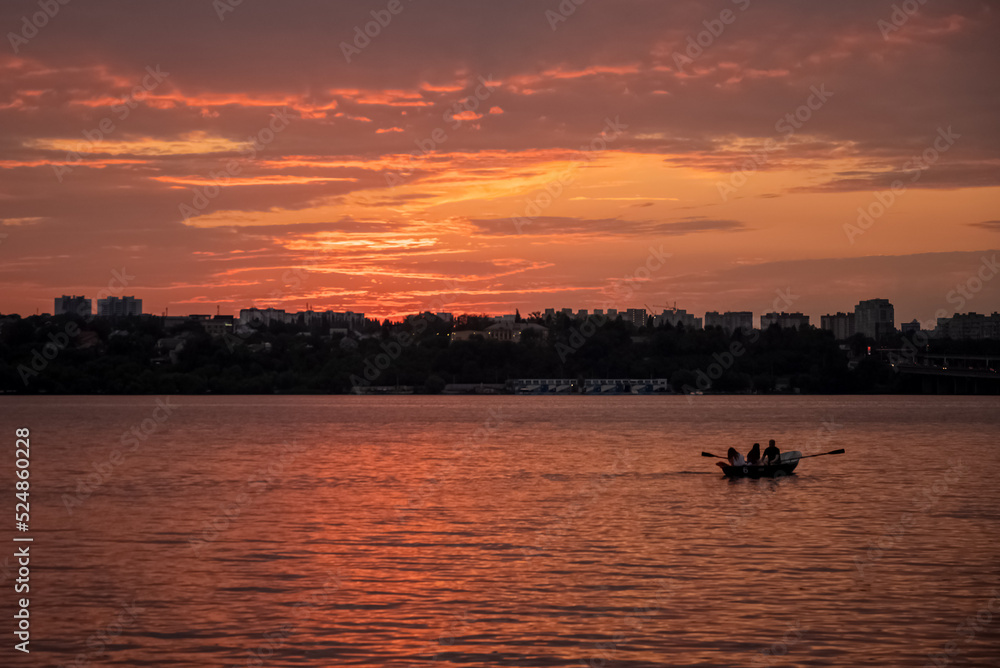 people boating on lake at sunset on summer evening