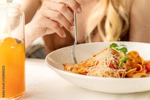 Woman eats pasta using fork close up