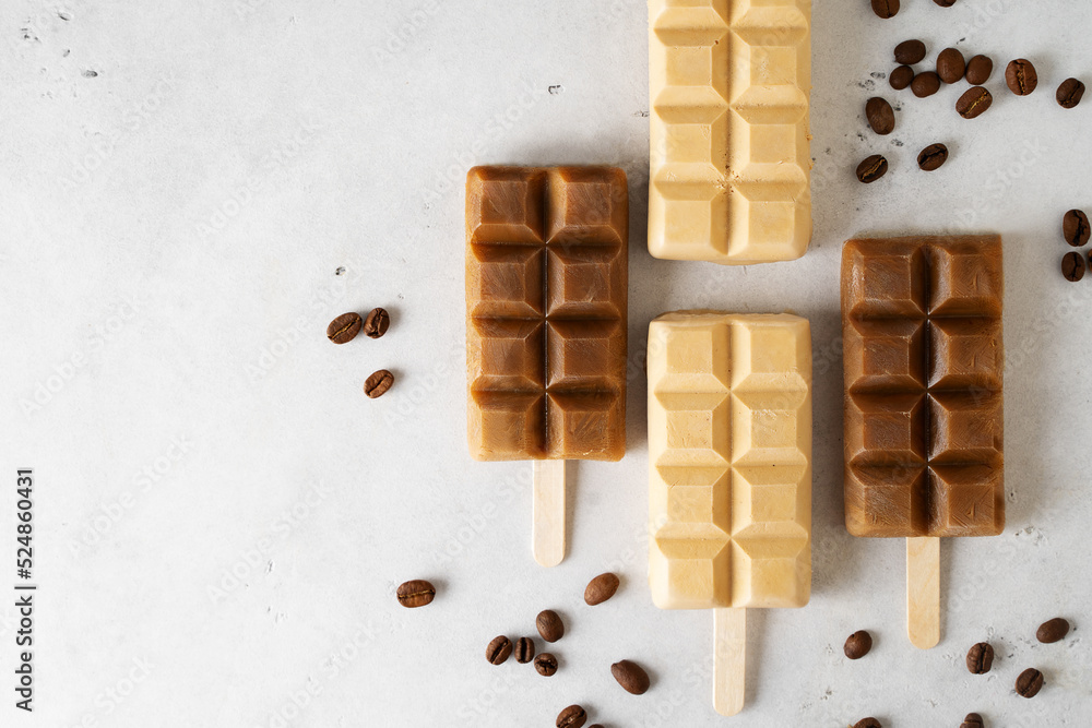 Coffee popsicle ice cream dessert with coffee beans on white background Coffee popsicle ice cream dessert with coffee beans on white background