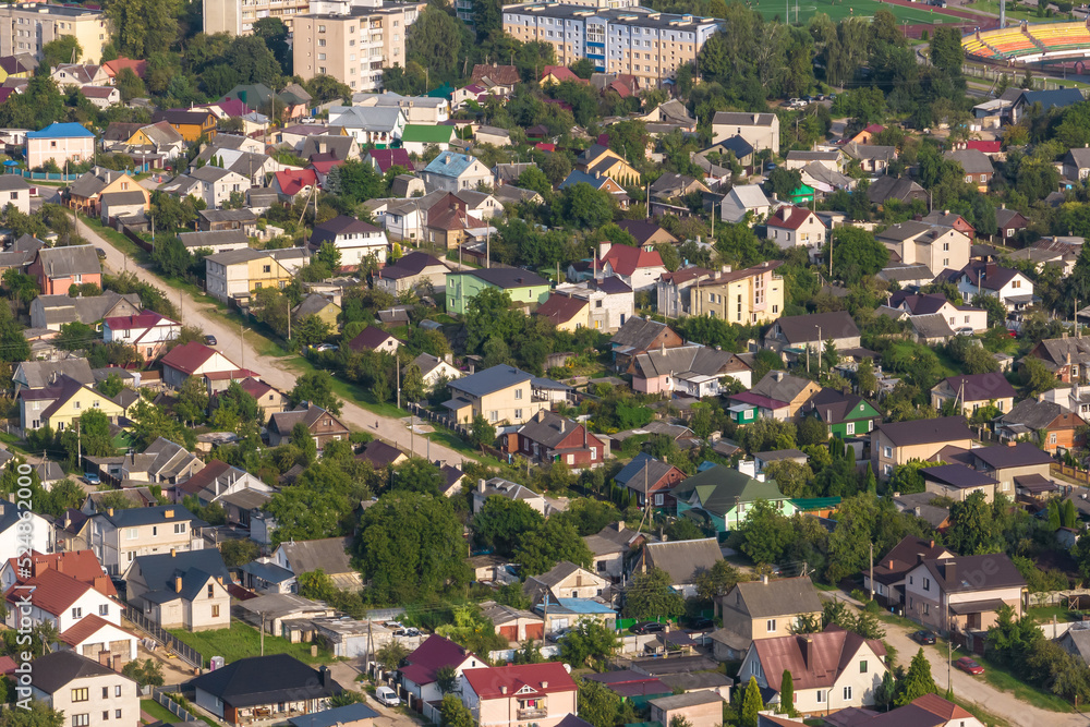 aerial panoramic view of green village with homestads, houses, barns and gravel road in forest