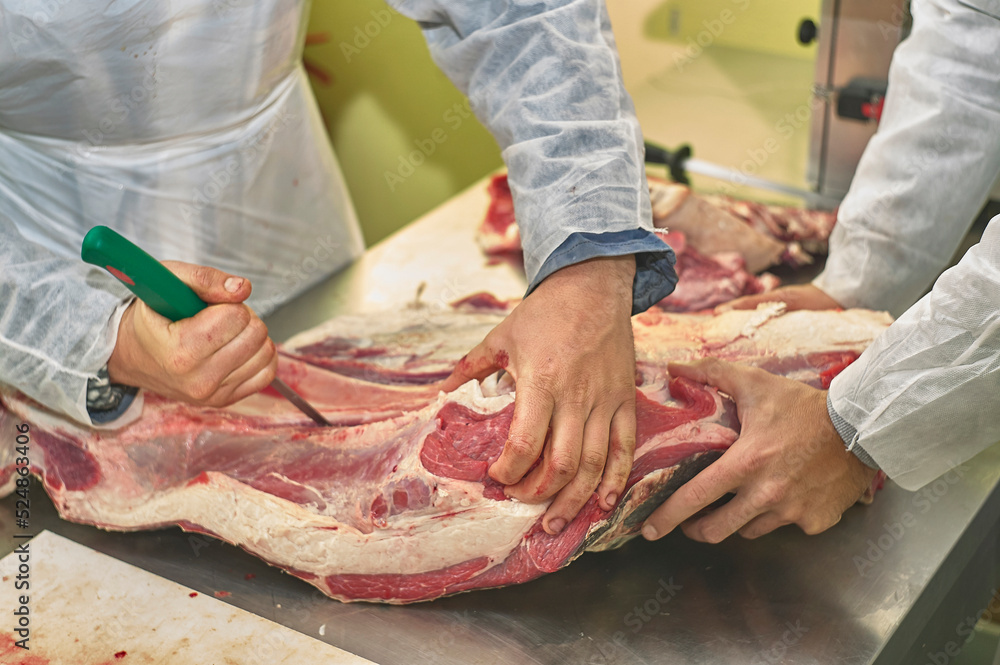Butcher removing fat from a meat cut