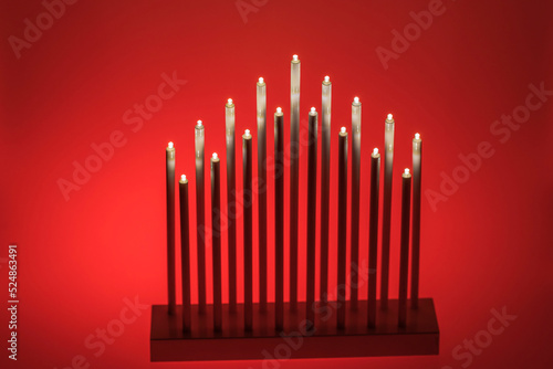 Close up view of traditional electrical Christmas candlestick isolation on red background. Sweden.