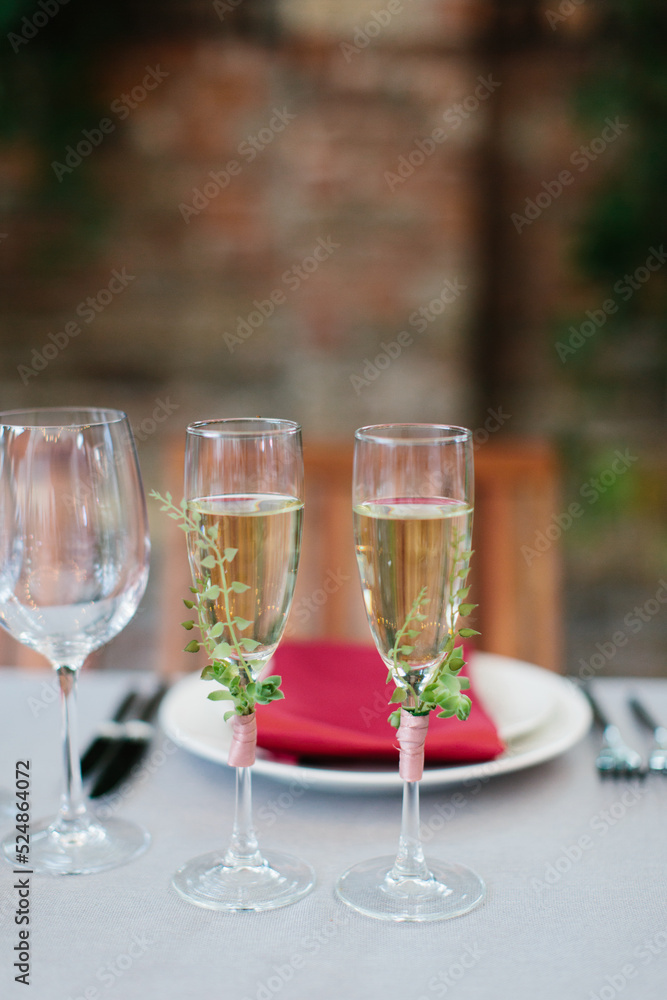 Two glasses of white wine, decorated with sprigs of greens. Two glasses of white wine, decorated with sprigs of greens.