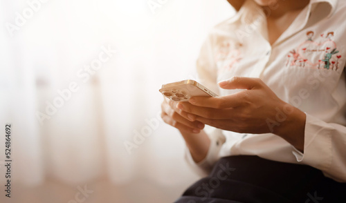 Close-up of a woman's hand using a mobile phone at home. Search ideas or social networks.