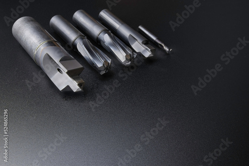 cutting tools set (drill, reamer, endmill). used for metalwork. Material carbide and steel. Isolated on dark background. photo