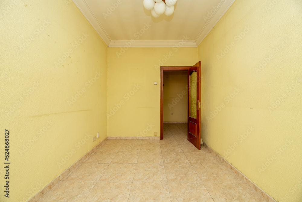 Empty room with light stoneware floor, yellow painted walls, white lampshade lamp and red wooden door Empty room with light stoneware floor, yellow painted walls, white lampshade lamp and red wooden door