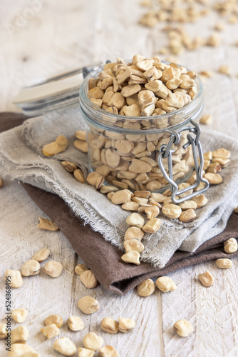 Glass jar of raw dry Grass pea on kitchen towel close up. Italian legumes Cicerchia photo