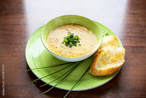 zupa krem z kabaczka i marchewki ze szczypiorkiem i grzankami na zielonym talerzu © adr77