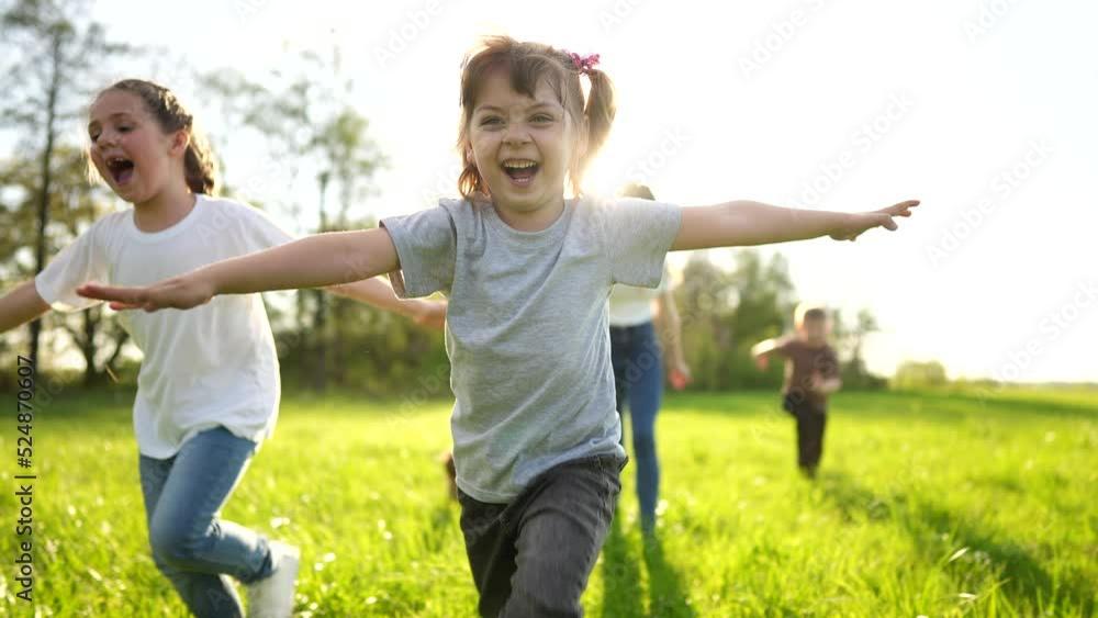 group of children running in the park. happy family baby kid dream concept. kindergarten. children hands to the sides play pilots plane run on the grass sun in the summer in the park group of children running in the park. happy family baby kid dream concept. kindergarten. children hands to the sides play pilots plane run on the grass sun in the summer in the park