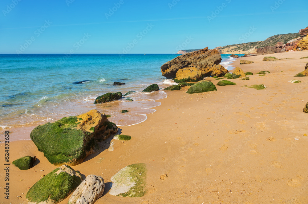 Atlantic coast with stones, sand and clear water.