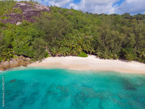 Fototapeta Naklejka Na Ścianę i Meble -  Aerial view from drone of Anse Soleil beach at Mahé Island taken in the afternoon light above the ocean