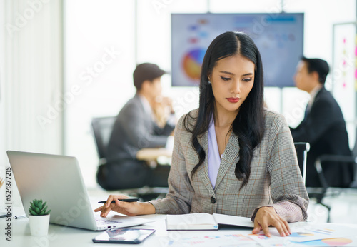 Young happy Asian businesswoman working and use a computer laptop and thinking idea for her business