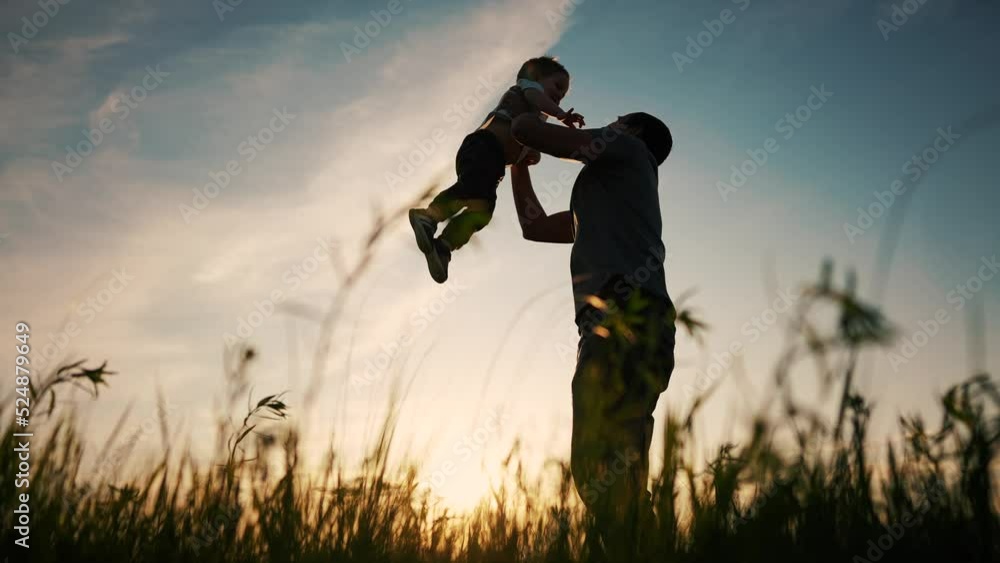 father playing with son in the park. happy family kid dream concept. father throws baby up silhouette in summer at sunset. parent and child play toss up silhouette outdoors in lifestyle the park father playing with son in the park. happy family kid dream concept. father throws baby up silhouette in summer at sunset. parent and child play toss up silhouette outdoors in lifestyle the park