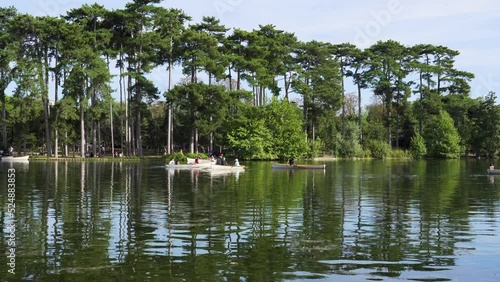 Parisians boating on the lower lake in the Bois de Boulogne on a summer week-end day - Paris, France photo