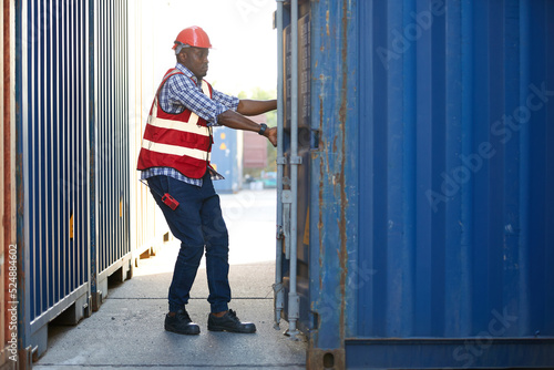 African factory worker or foreman opening the container door in warehouse storage © offsuperphoto