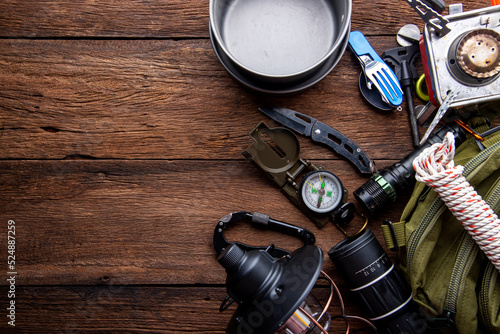 Outdoor travel equipment planning. camping trip on wooden table background.