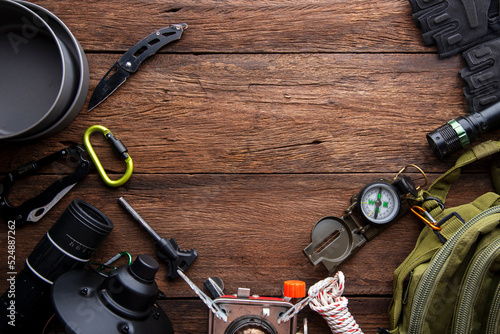 Outdoor travel equipment planning. camping trip on wooden table background.